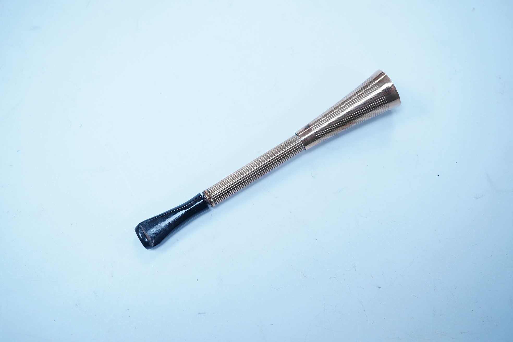 A 9ct gold mounted cigarette holder, with plastic mouthpiece, 78mm, gross weight 8.1 grams. Condition - fair to good